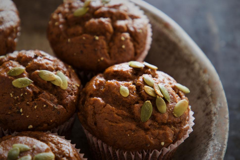 Free Image of Pumpkin muffins topped with seeds on tray 