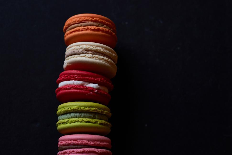 Free Image of Colorful macarons stacked in a dark setting 