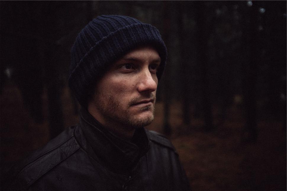 Free Image of Pensive man in forest with knit hat 