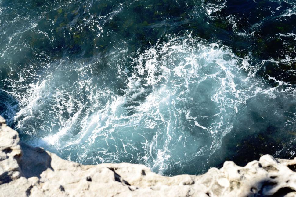 Free Image of Churning sea foam from a coastal cliff 