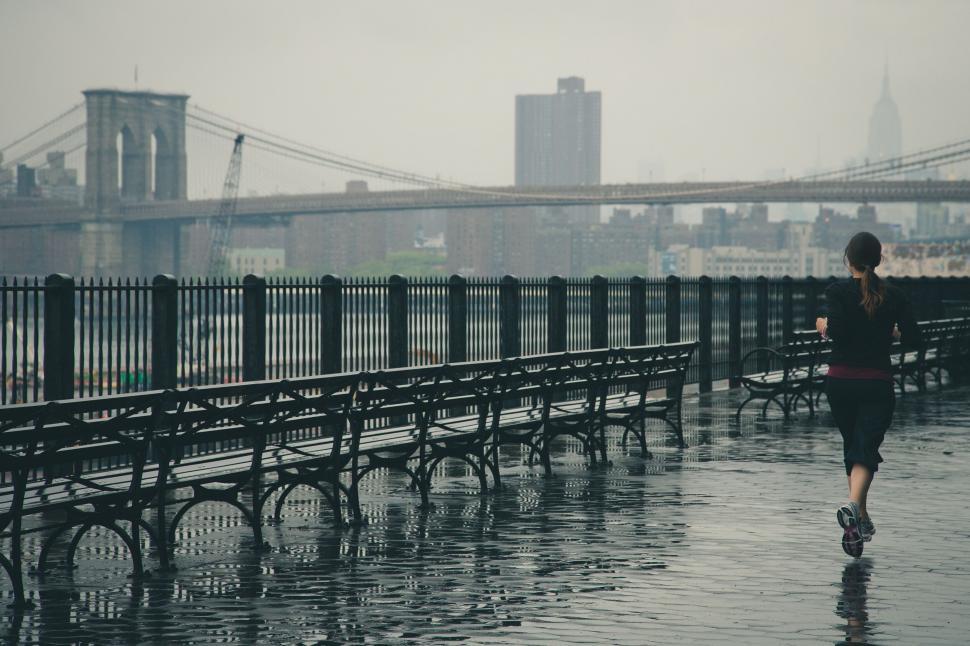 Free Image of Running woman on a wet promenade 