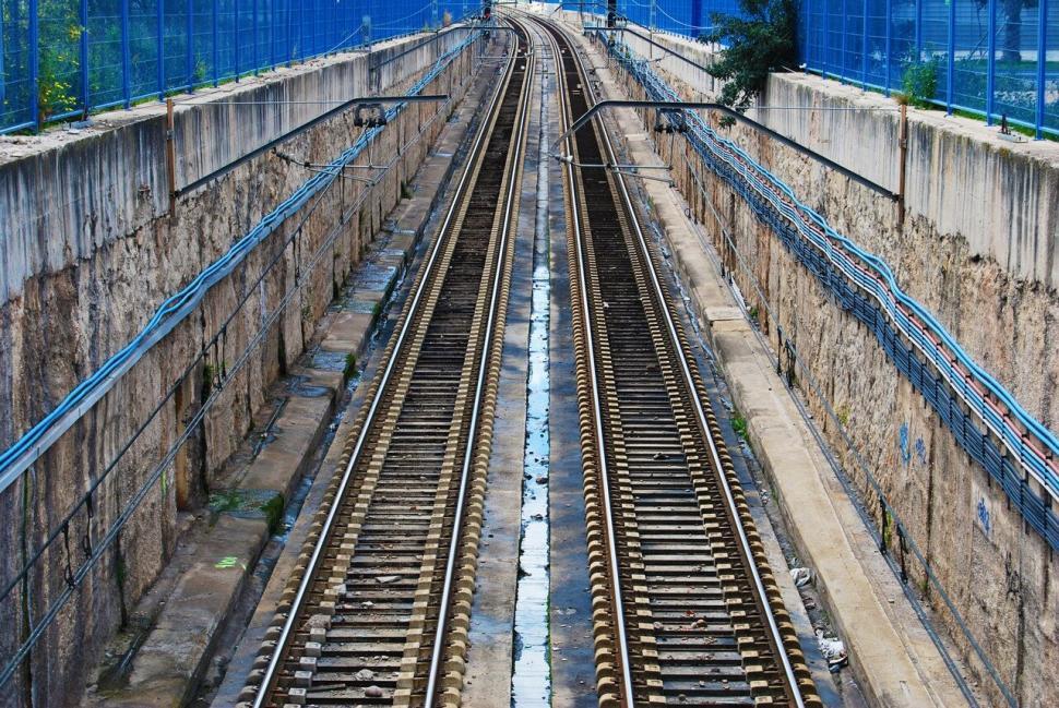 Free Image of Converging railway tracks surrounded by walls 