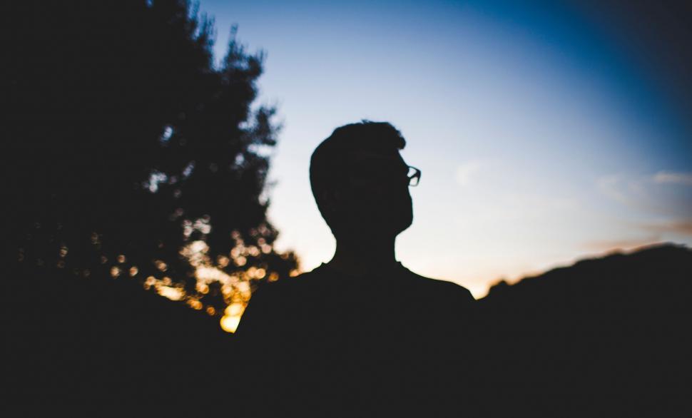 Free Image of Silhouette of a person at sunset with trees 