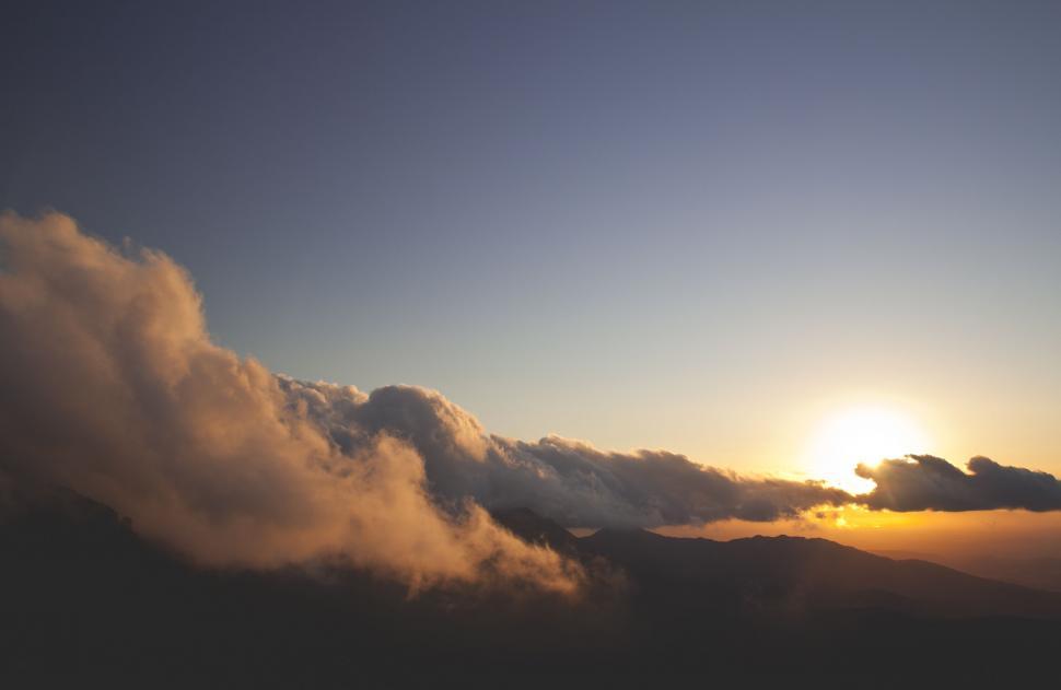 Free Image of Sunset over mountains with dramatic clouds 