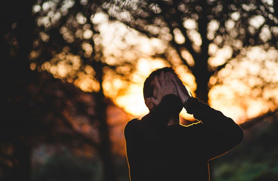 Free Image of Man holding head during sunset silhouette 