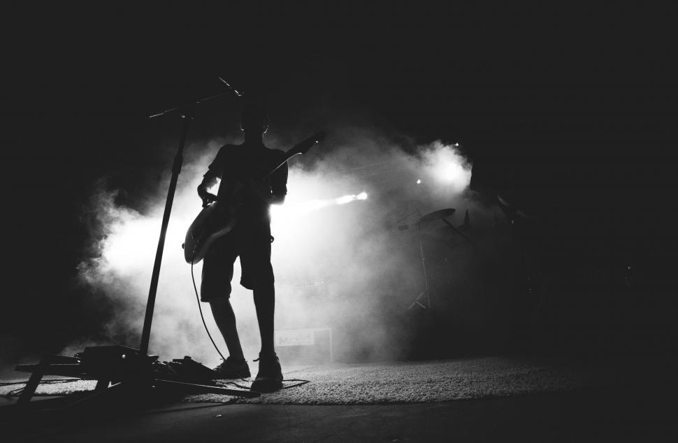 Free Image of Silhouette of musician on stage with guitar 