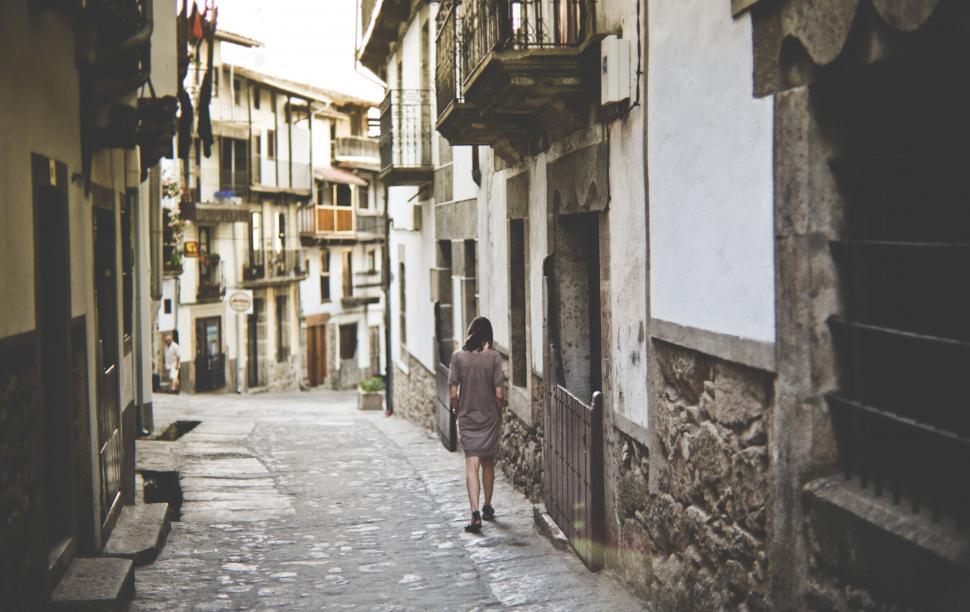 Free Image of Woman walking in historic European alley 