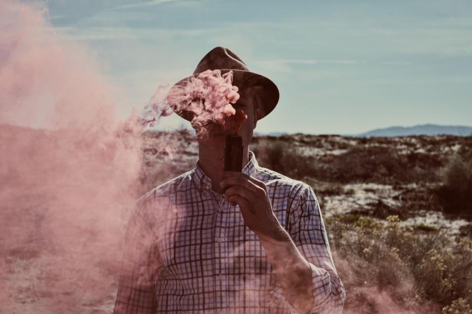 Free Image of Man concealed by red smoke holding book 