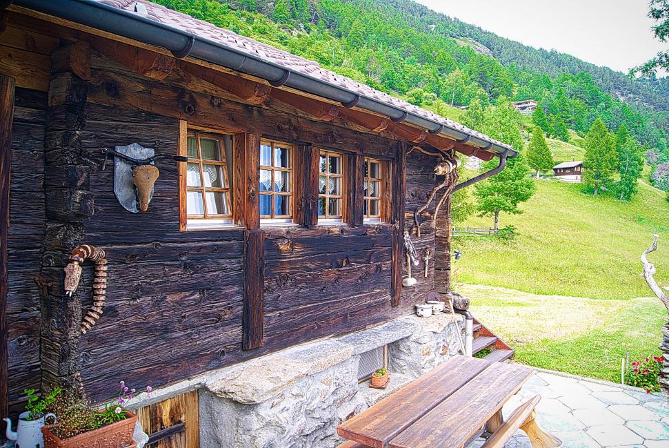 Free Image of Traditional alpine cabin in summer greenery 