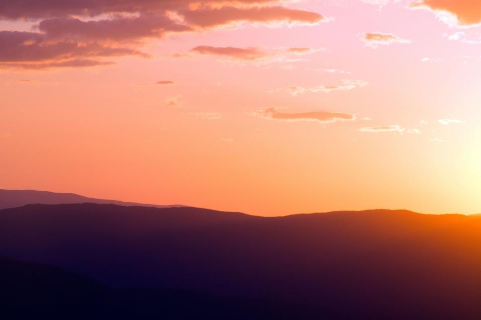 Free Image of Sunset hues over layered mountain silhouette 