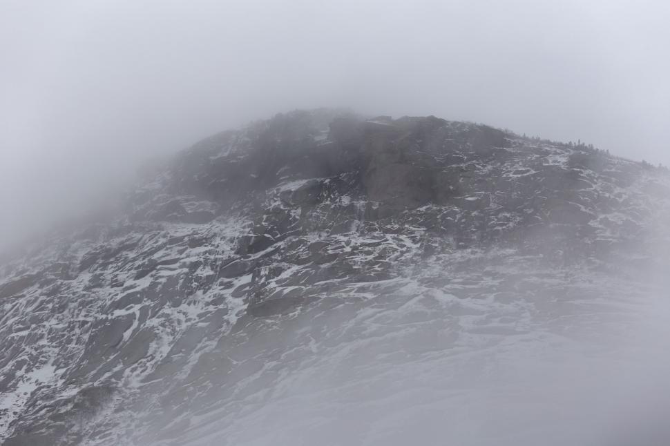 Free Image of Misty mountain top with snow patches 