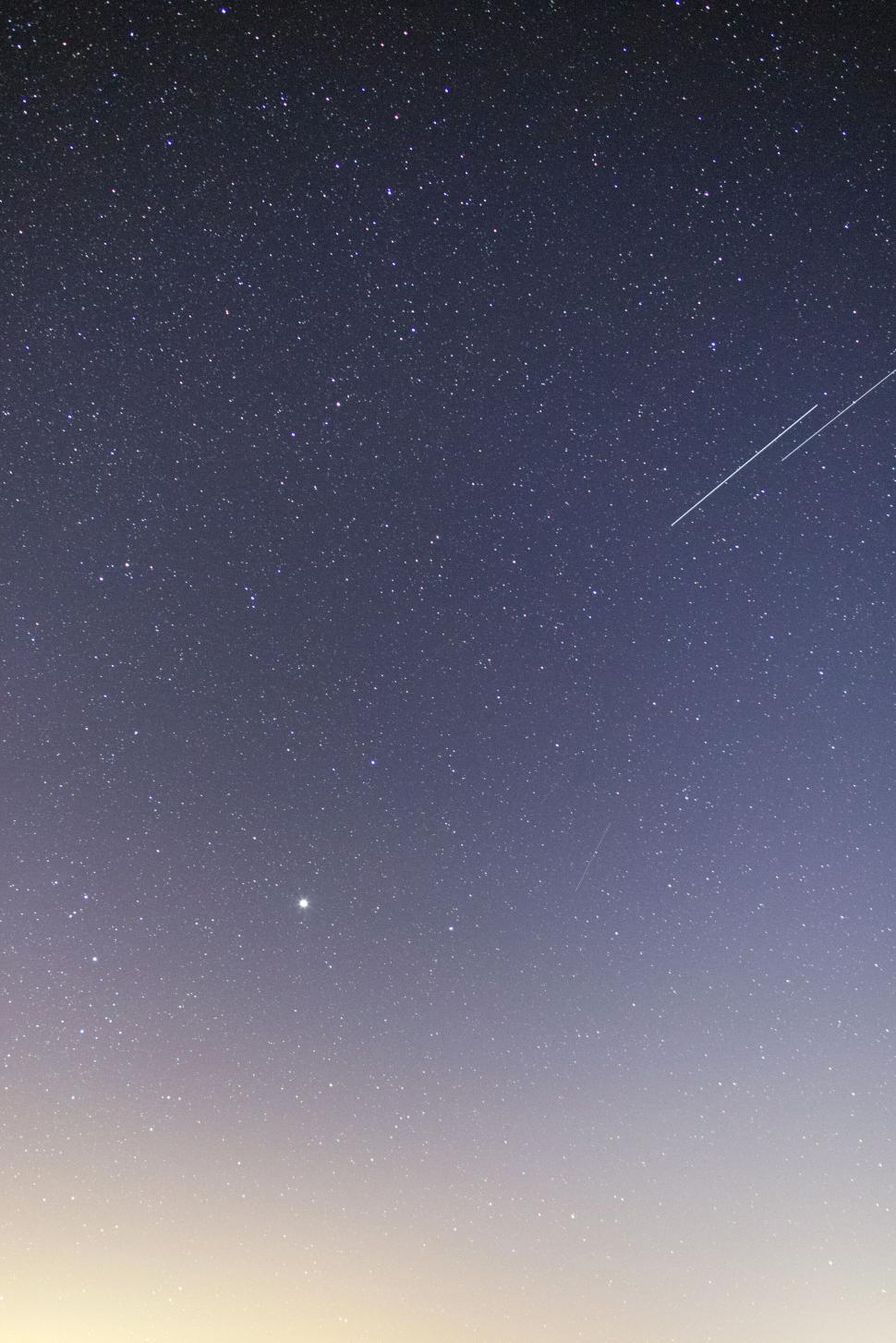 Free Image of Star-studded sky with visible meteor trails 