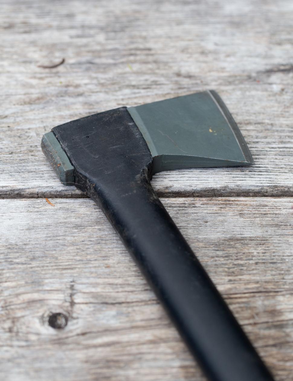 Free Image of Close-up of an axe on weathered wood 