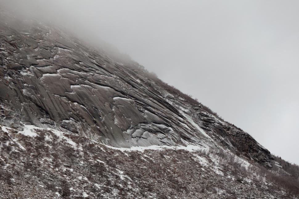 Free Image of Snowy mountain slope with exposed rocks 