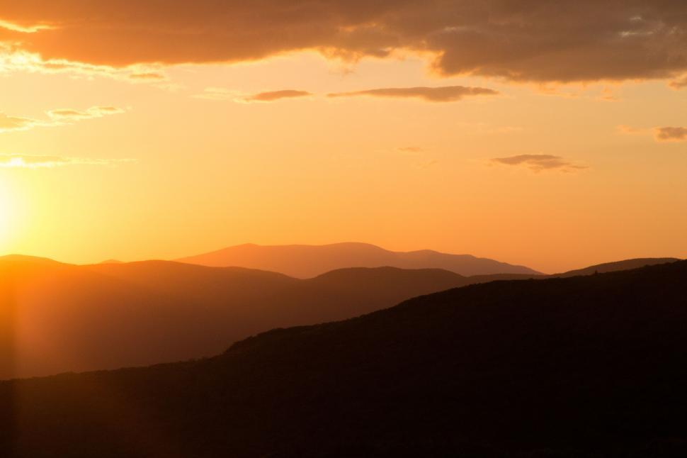 Free Image of Golden hour over rolling mountain landscape 
