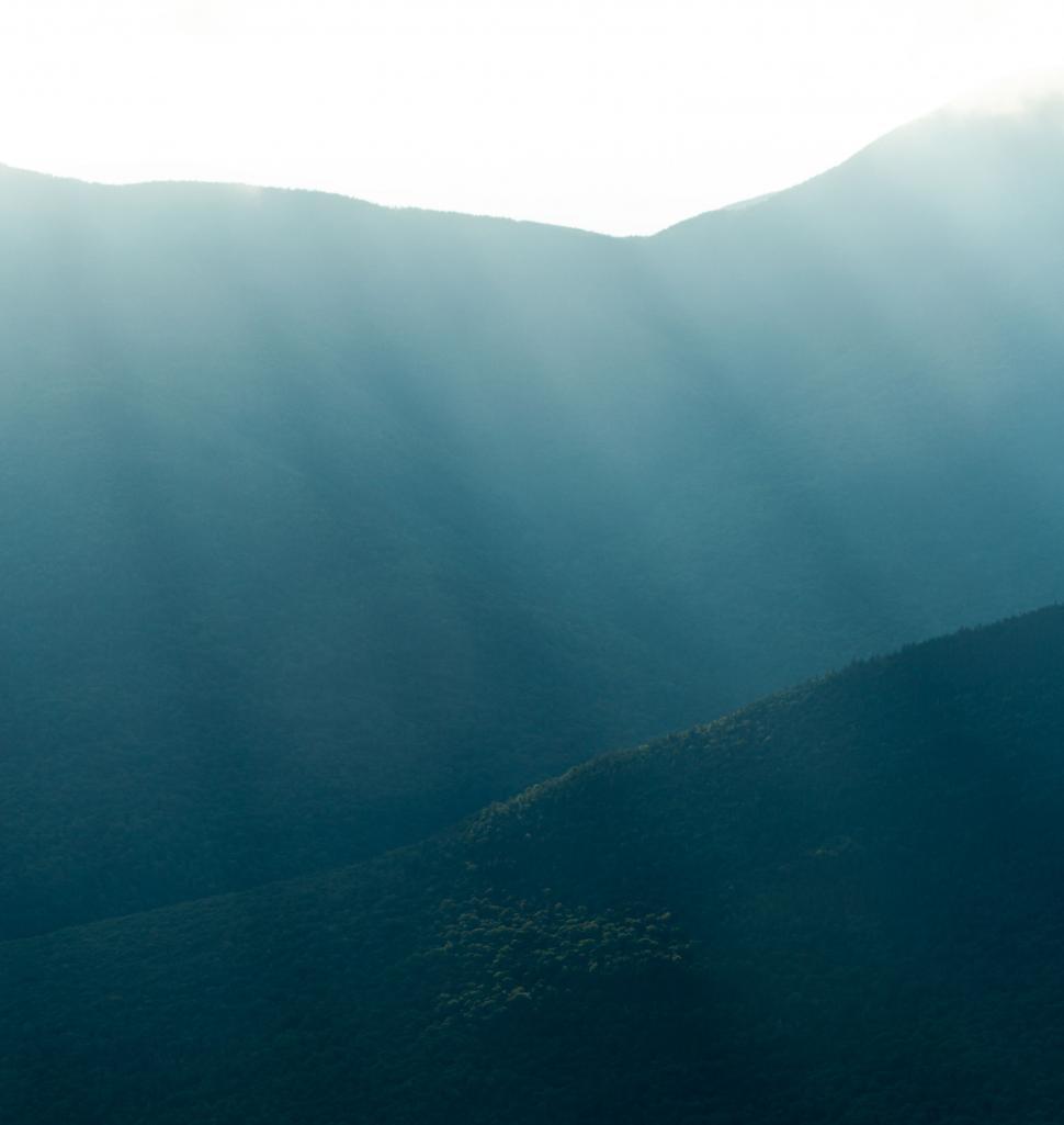 Free Image of Misty mountains with sunlight filtering through 