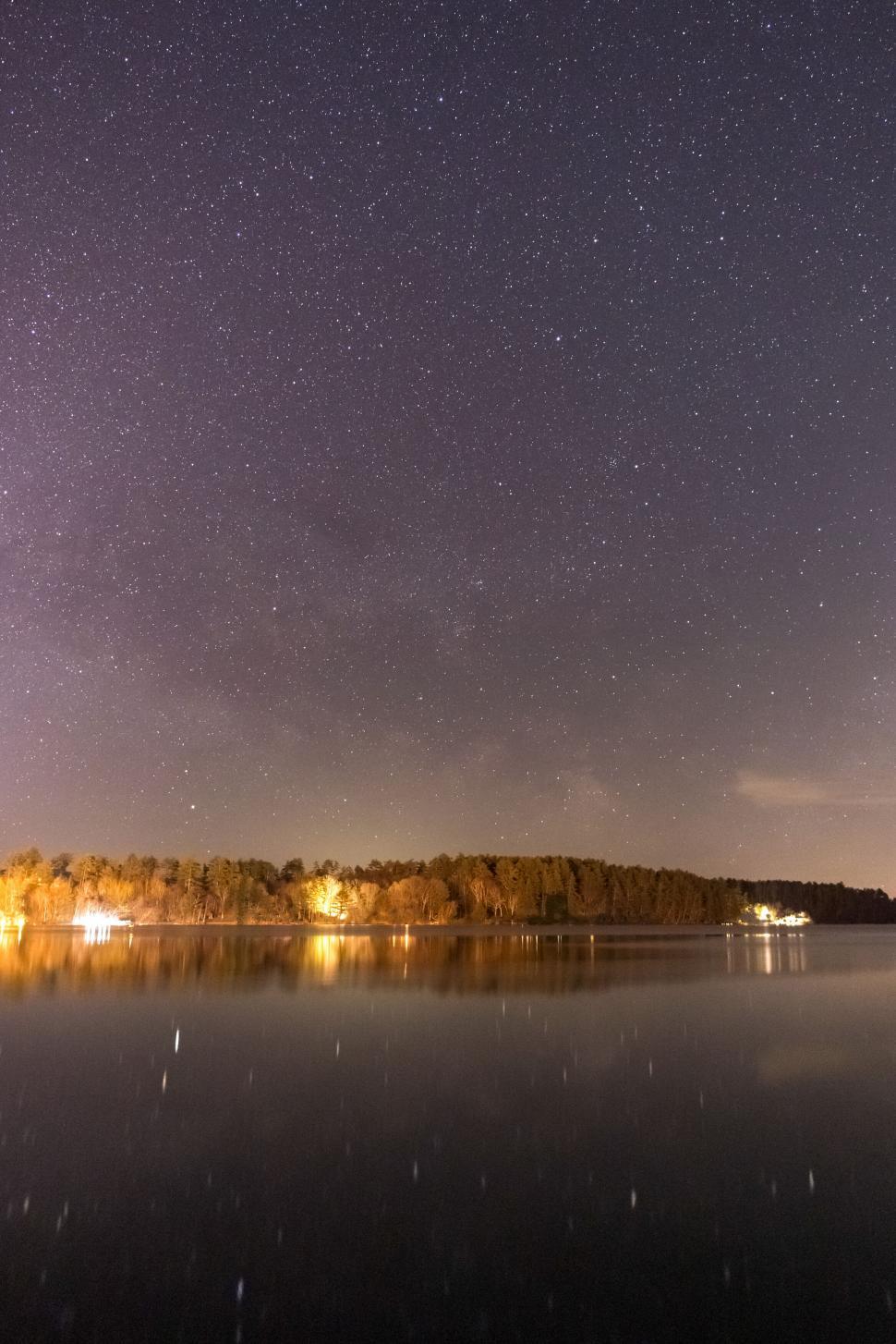 Free Image of Starry night sky reflecting on a calm lake 