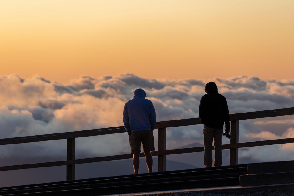 Free Image of Two friends enjoy a cloudy sunset view 