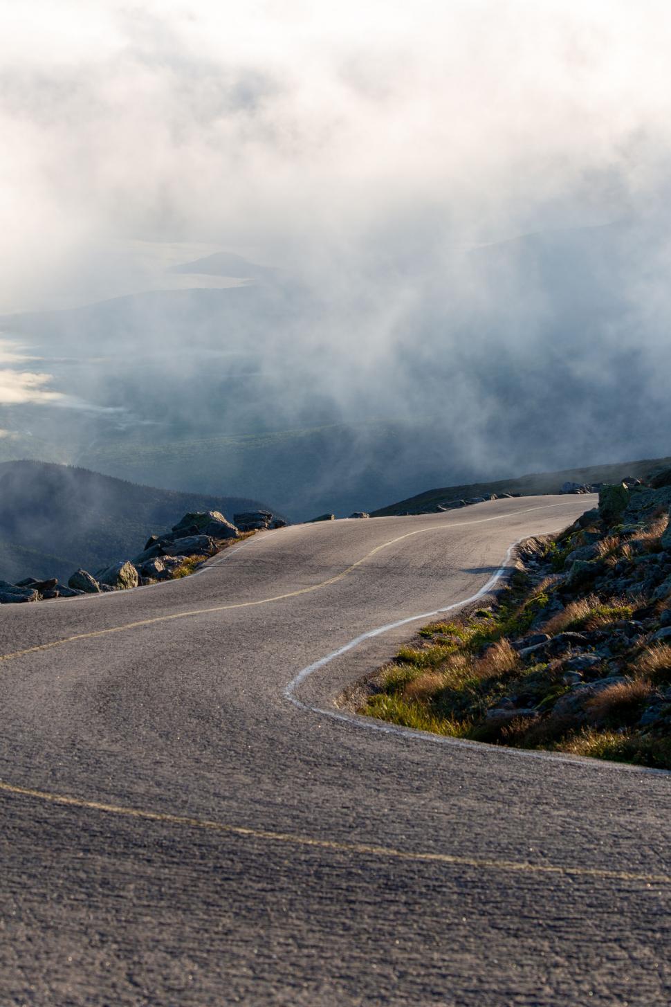 Free Image of Winding road disappearing into foggy distance 