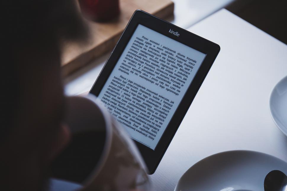 Free Image of Reading on a Kindle during coffee break 