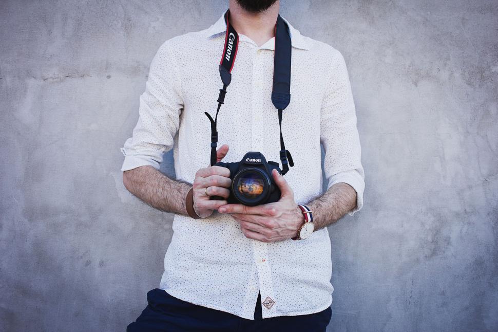 Free Image of Man holding a camera with a reflection 