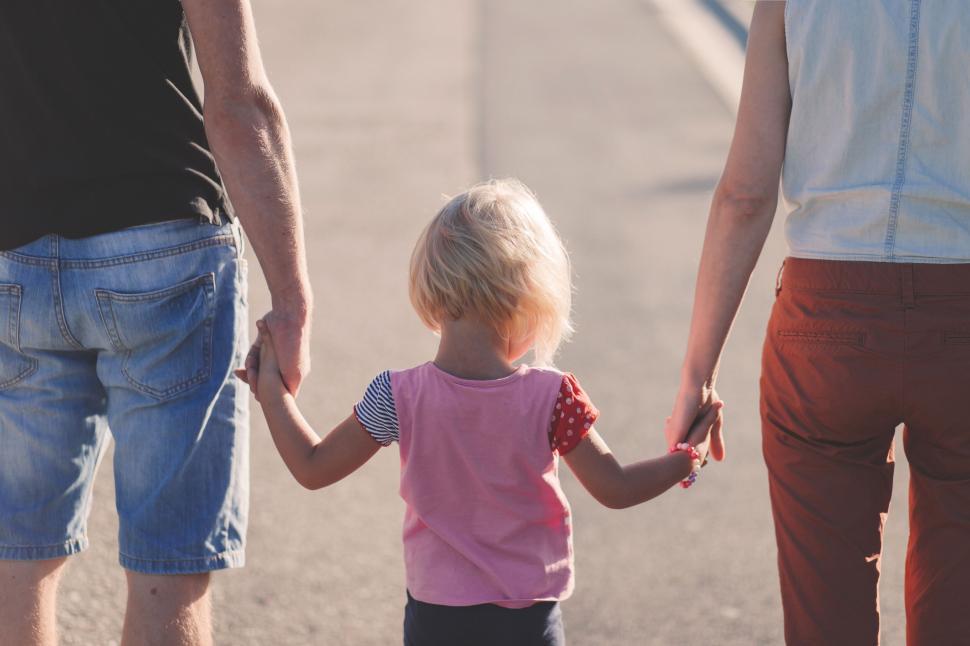 Free Image of Family holding hands with toddler walking 