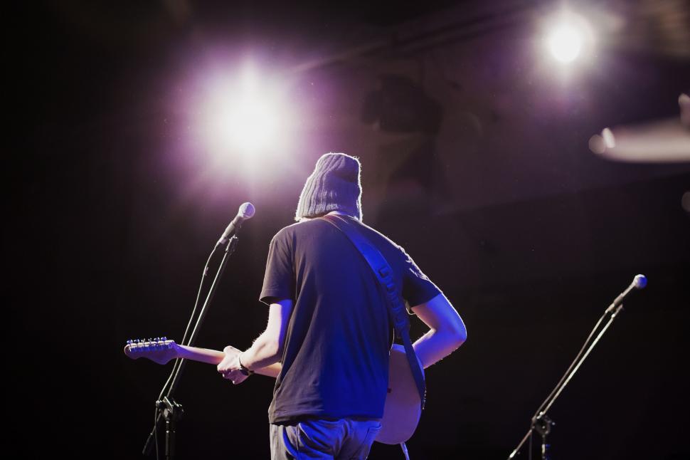Free Image of Musician on stage from behind under spotlight 