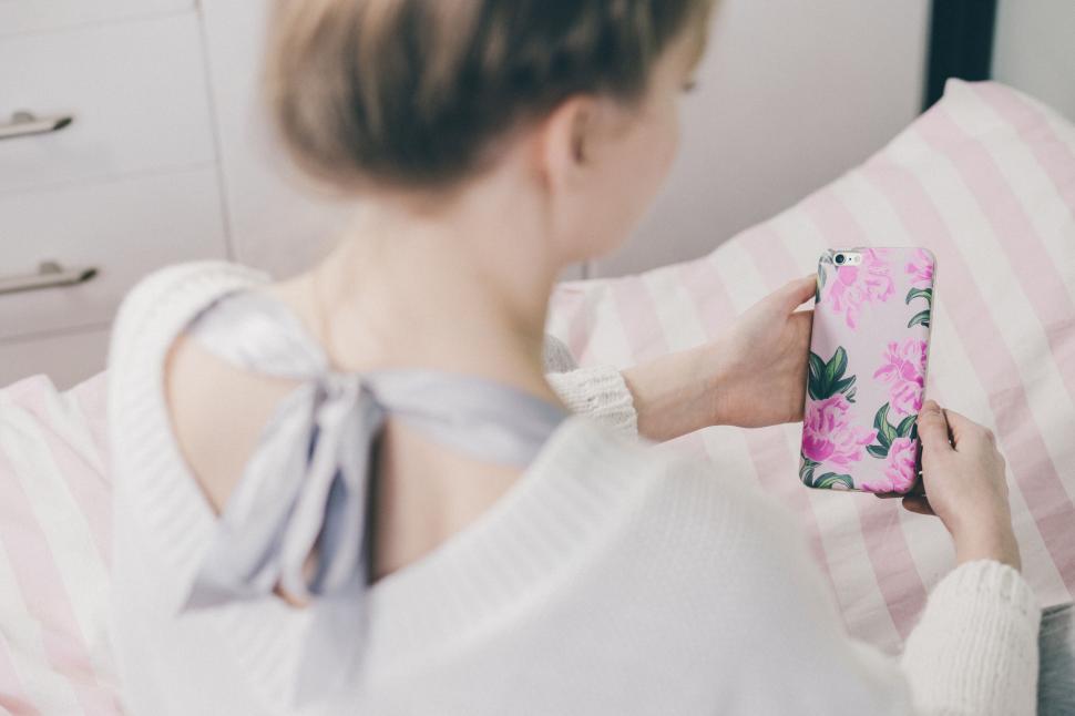 Free Image of Woman holding phone with floral case 
