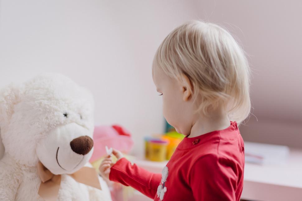 Free Image of Child playing doctor with teddy bear 