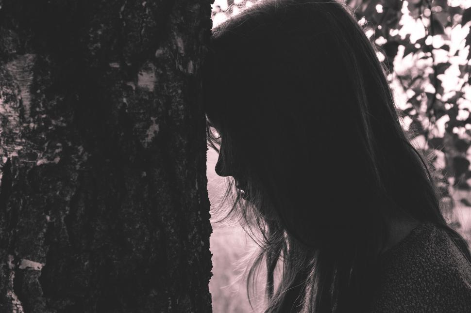 Free Image of Silhouette of a woman by a tree 