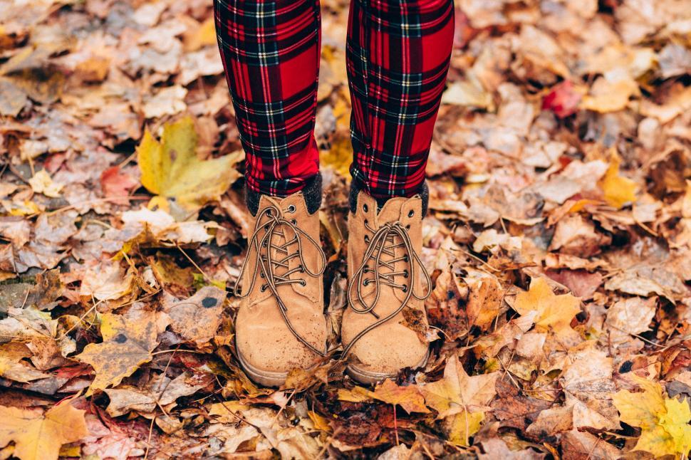 Free Image of Person standing in fall leaves wearing boots 