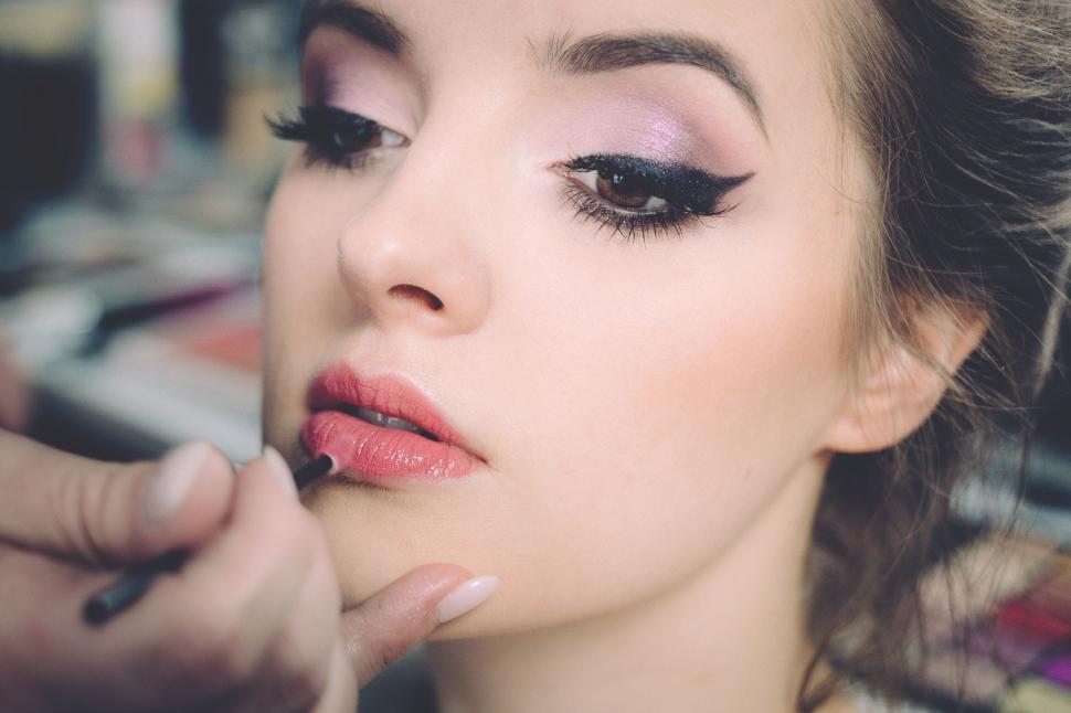 Free Image of Makeup artist applying lipstick on a client 
