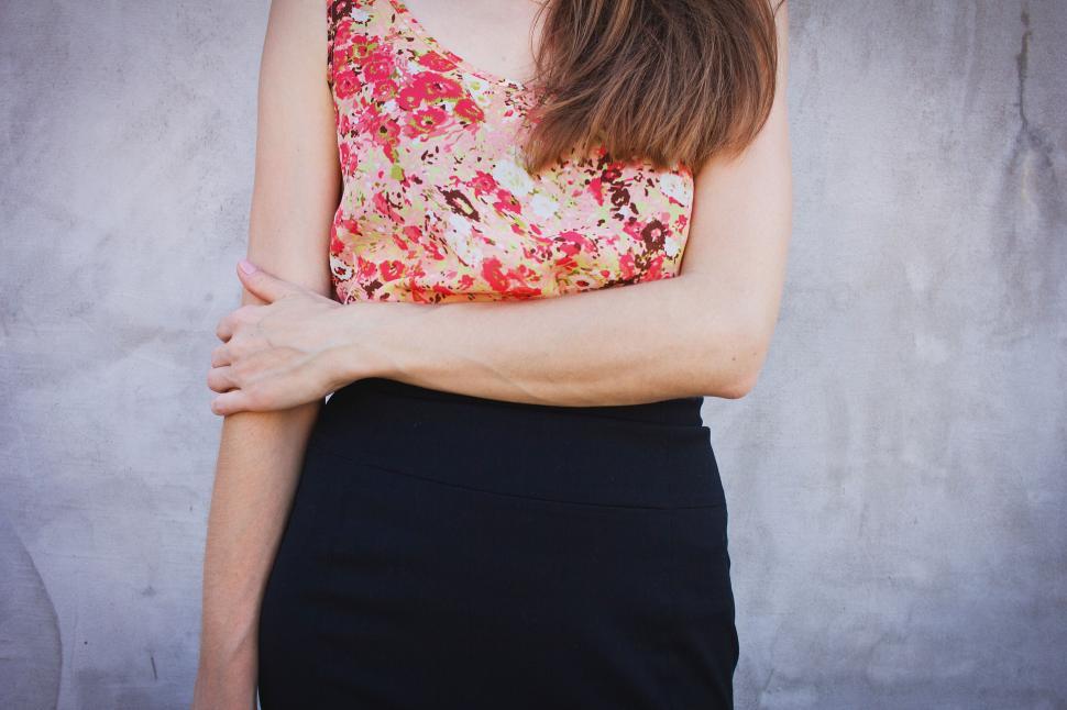 Free Image of Woman in floral blouse with arms crossed 