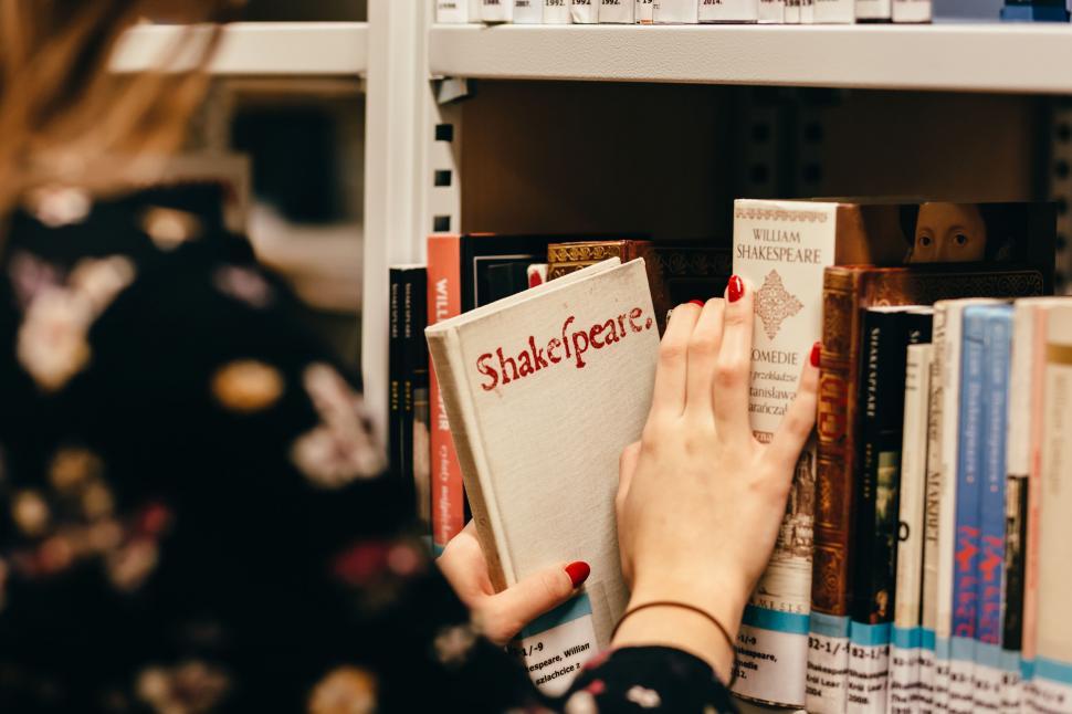 Free Image of Woman selecting book from shelf 