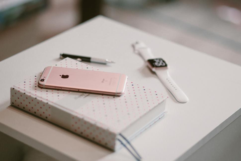 Free Image of Rose gold iPhone on a dotted notebook 