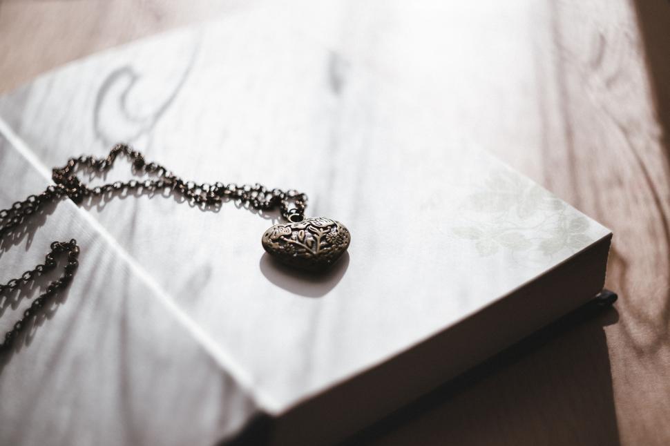 Free Image of Vintage necklace on a book in warm light 