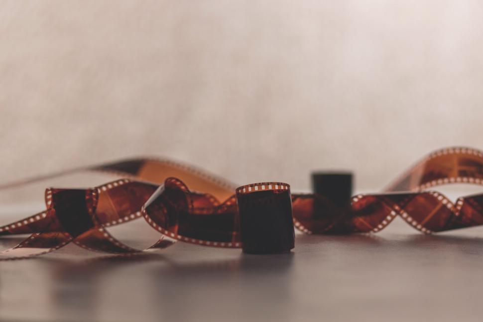 Free Image of Film strip with blurred background in warm tones 