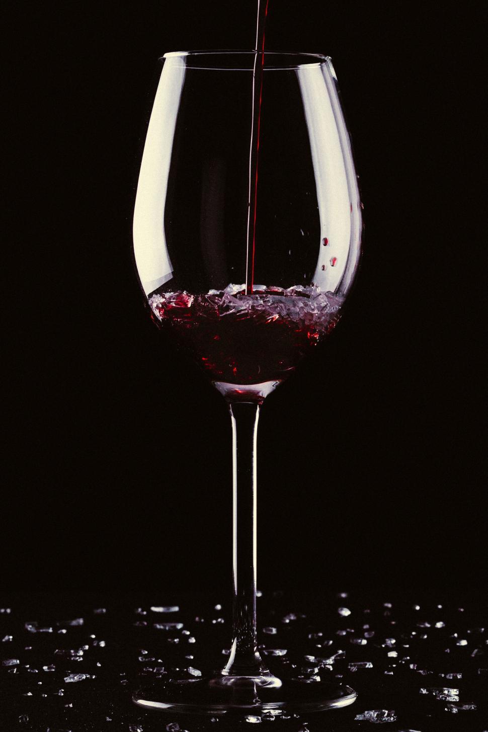 Free Image of Red wine pouring into glass at dark 