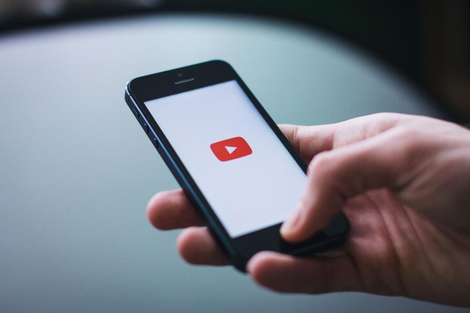 Free Image of Person using iPhone with YouTube logo on screen 