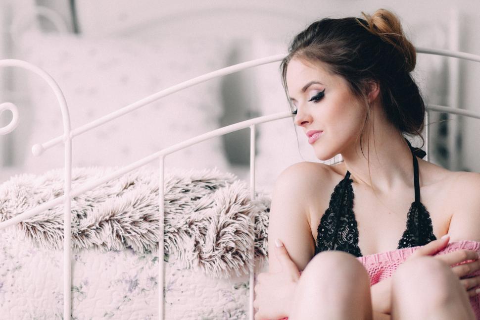 Free Image of Woman sitting on bed in lingerie 