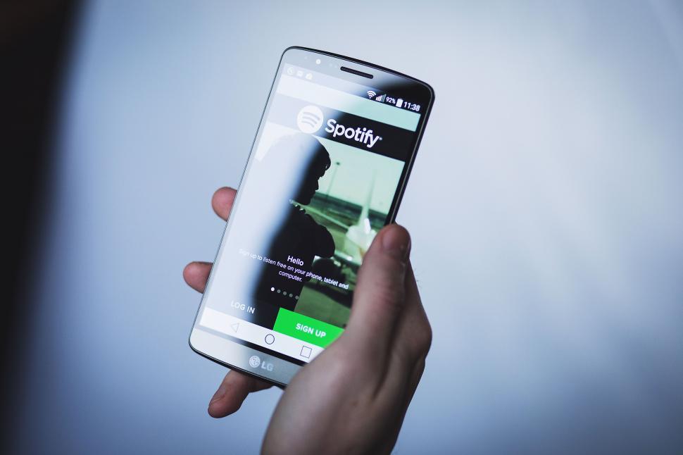 Free Image of Hand holding phone with Spotify on screen 
