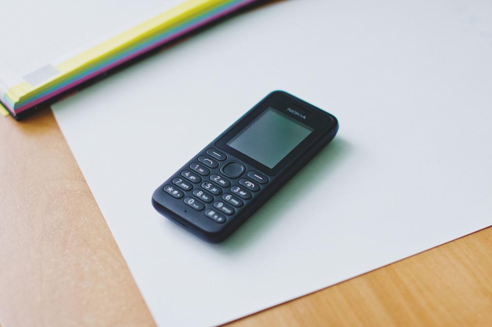 Free Image of Compact Mobile Phone on White Paper 