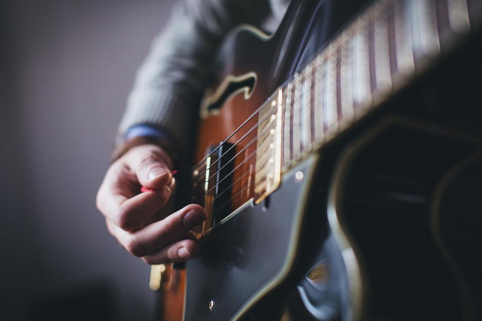 Free Image of Close-up of a man playing an archtop guitar 