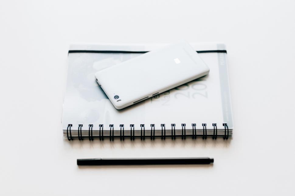 Free Image of Minimalistic white smartphone on a planner 
