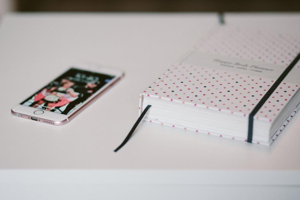 Free Image of Smartphone resting on polka dot diary 
