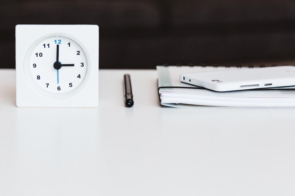 Free Image of Desk with clock, notebook, and smartphone 