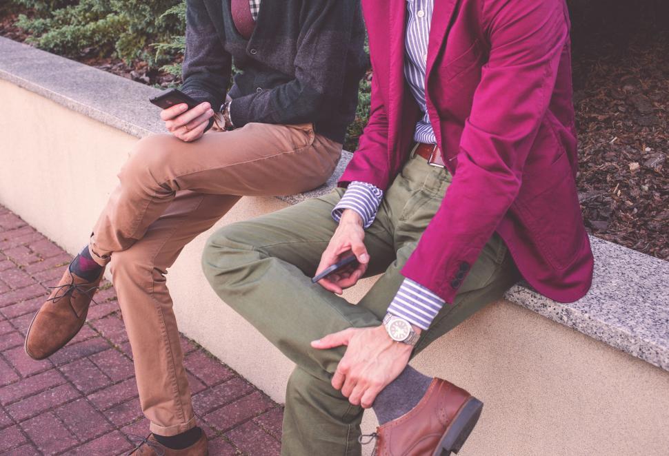 Free Image of Two men in stylish outfits using smartphones 