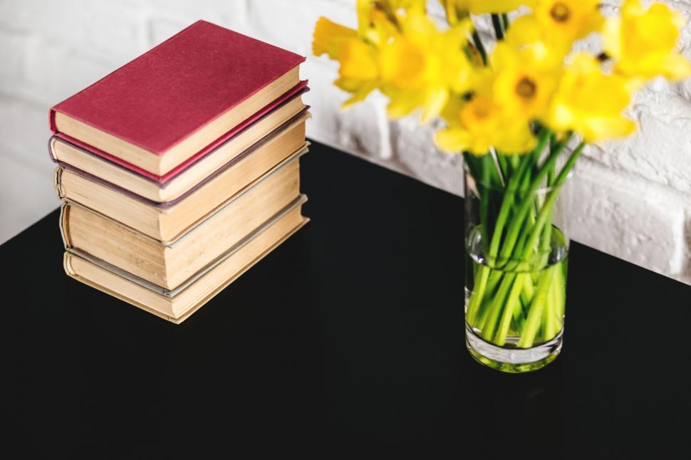 Free Image of Books and fresh daffodils on black table 