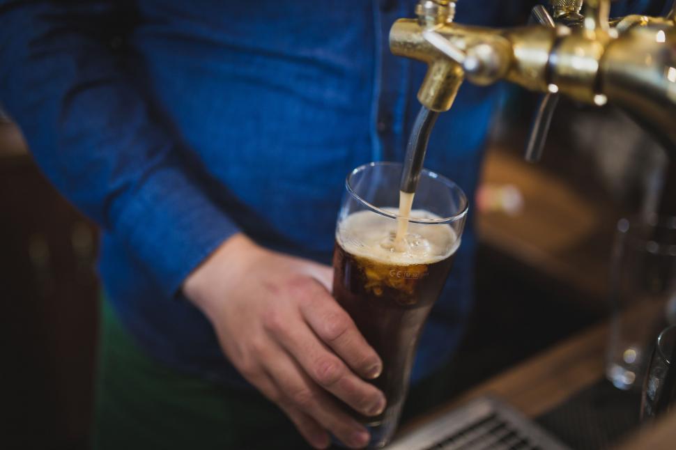 Free Image of Bartender pouring a beer at a pub 