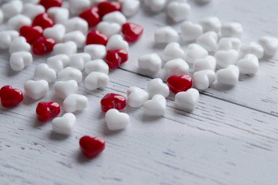Free Image of White and Red Candy Hearts Scattered on Wood 